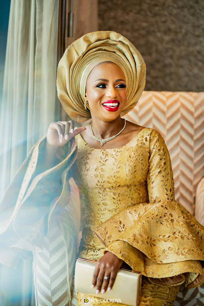 Kemi looking regal in her gold traditional outfit and laughing 