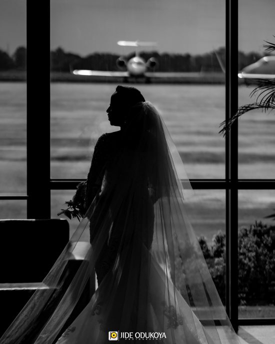 Bride in her wedding dress in front of an airplane